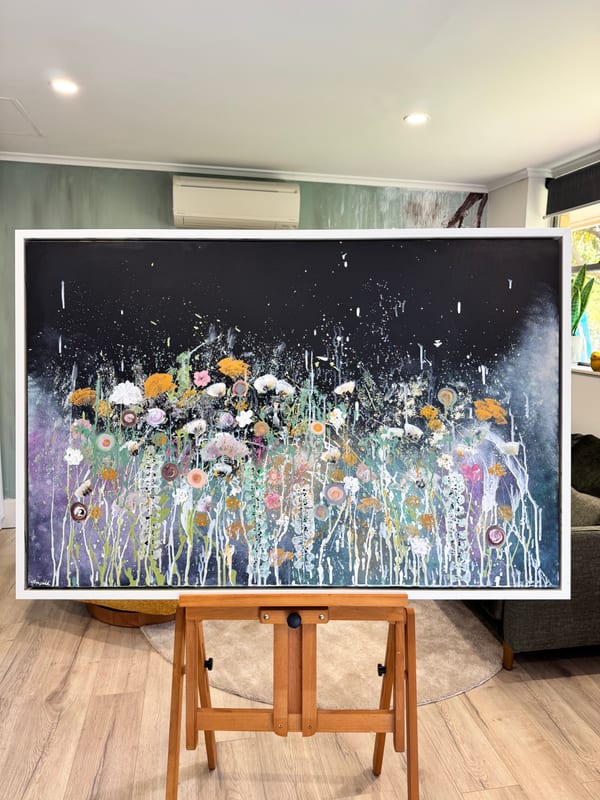 One of her large flower paintings on an easel in a living room